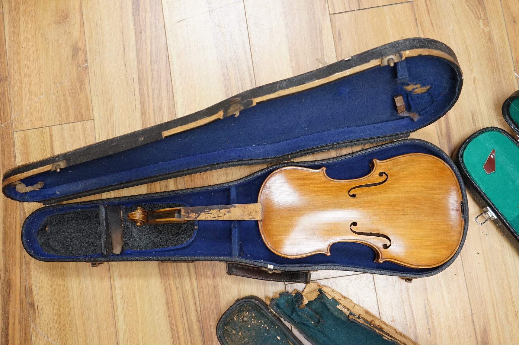 Three cased violins; a German Dresden violin, supplied by Campbell and co., Glasgow, together with another Dresden Stradivarius copy, and the remains of a European violin.